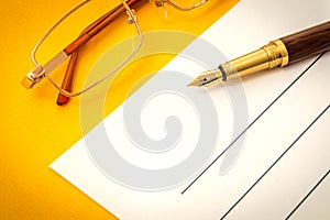 Beautiful office still life on a yellow table with pen and glasses