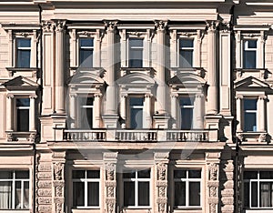 Beautiful old classical facade of the building. Windows with balcony, columns and moldings