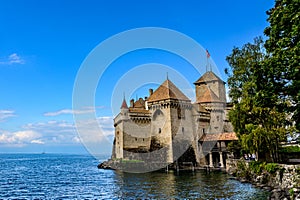 Beautiful old gothic style castle by the lake in blue sky.