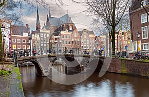 Beautiful old houses on the city embankment of Amsterdam at sunset.