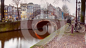 Beautiful old houses on the city embankment of Amsterdam at sunset.