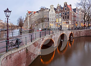 Beautiful old houses on the city embankment of Amsterdam at sunset.