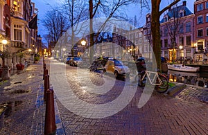 Beautiful old houses on the city waterfront of Amsterdam at sunset.