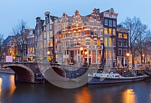 Beautiful old houses on the city waterfront of Amsterdam at sunset.