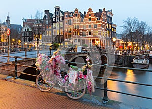 Beautiful old houses on the city waterfront of Amsterdam at sunset.