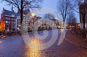 Beautiful old houses on the city waterfront of Amsterdam at sunset.