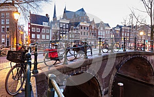 Beautiful old houses on the city waterfront of Amsterdam at sunset.