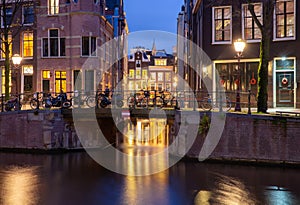 Beautiful old houses on the city waterfront of Amsterdam at sunset.