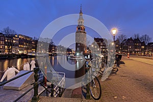 Beautiful old houses on the city waterfront of Amsterdam at sunset.