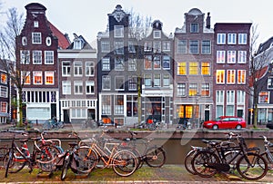 Beautiful old houses on the city waterfront of Amsterdam at sunset.