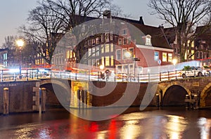 Beautiful old houses on the city waterfront of Amsterdam at sunset.