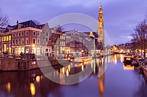 Beautiful old houses on the city waterfront of Amsterdam at sunset.