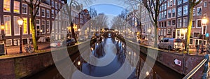 Beautiful old houses on the city waterfront of Amsterdam at sunset.