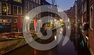 Beautiful old houses on the city waterfront of Amsterdam at sunset.