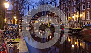 Beautiful old houses on the city waterfront of Amsterdam at sunset.