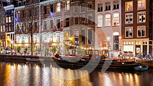 Beautiful old houses on the city waterfront of Amsterdam at sunset.