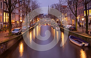 Beautiful old houses on the city waterfront of Amsterdam at sunset.