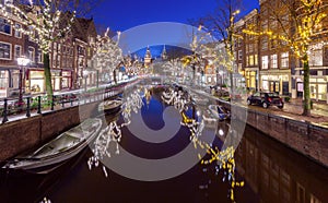 Beautiful old houses on the city waterfront of Amsterdam at sunset.