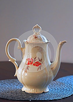 Beautiful old ivory white porcelain teapot with red flowers