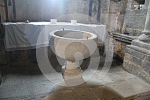 Beautiful old stone baptismal font where it is converted to Christianity photo