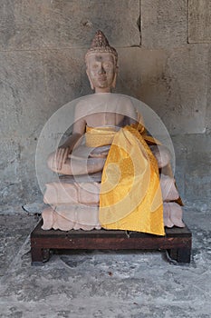 Beautiful stone statue of buddha with yellow scarf in ancient angkor wat temple, religous site for hindu and buddhism photo