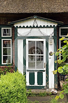 Beautiful old wooden front door in green and white on a typical