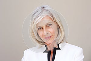 Beautiful older woman staring standing by wall