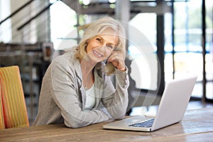 Beautiful older woman working laptop computer indoors