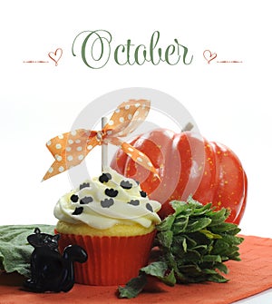 Beautiful orange Halloween theme cupcake with seasonal flowers and decorations for the month of October photo