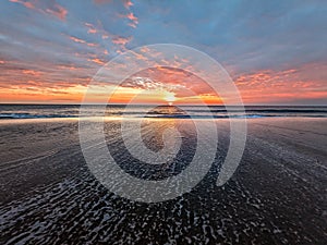 Beautiful orange red sky sunrise sunset outer banks north Carolina sand waves nags head kittyhawk Corolla foam shore morning