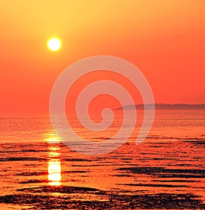 Beautiful orange red sunset sky over low tide water sea ocean reflections sun sunny summer holiday coastal scenes scenic landscape