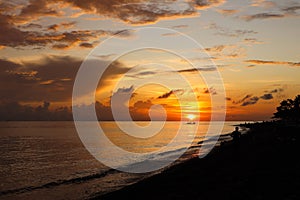 Beautiful orange sky illuminated by the sunset with a beach in the foreground in Amed, Bali photo