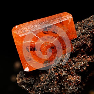 Beautiful orange wulfenite crystal on brown gossan matrix with scattered calcite crystals