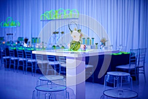 Unique orchid cocktail flower arrangement on lucite stools and table set up for a party in a ballroom photo