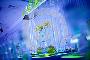 Beautiful orchid flower arrangement set up for a wedding party in a ballroom with lucite decoration photo