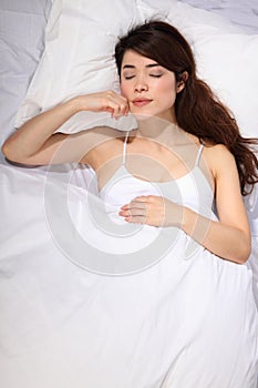 Beautiful oriental girl sleeping in bed