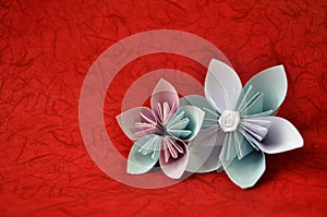 Beautiful origami flowers on red background / Origami flowers / Combined blue and white paper in origami flowers / Simple origami