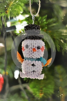 A beautiful origami snowman decorating Christmas tree