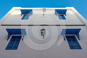 Beautiful ornamental blue windows on a white wall, Yasmine Hammamet, Tunisia photo