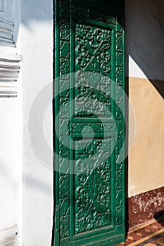 Beautiful ornate carvings on the green door of the Portuguese era Holy Spirit church in the old