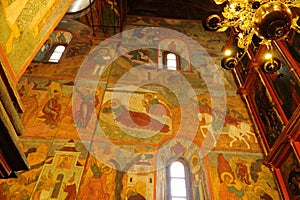 Beautiful ornate painted interior of Orthodox Church. Old frescoes with icons inside luxury Russian cathedral. Moscow