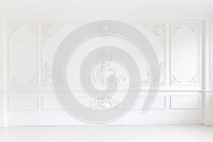 Beautiful ornate white decorative plaster mouldings in studio. The white wall is decorated with exquisite elements of photo