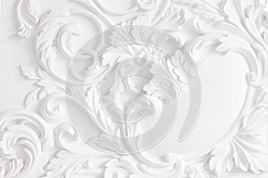 Beautiful ornate white decorative plaster mouldings in studio. The white wall is decorated with exquisite elements of