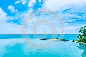 Beautiful outdoor infinity swimming pool in hotel resort with sea ocean view and white cloud blue sky