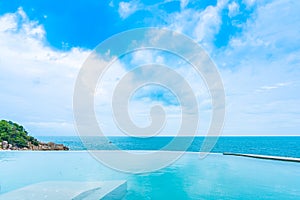 Beautiful outdoor infinity swimming pool in hotel resort with sea ocean view and white cloud blue sky