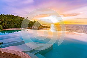 Beautiful outdoor infinity swimming pool in hotel resort with sea ocean view and white cloud blue sky