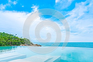 Beautiful outdoor infinity swimming pool in hotel resort with sea ocean view and white cloud blue sky