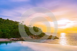 Beautiful outdoor infinity swimming pool in hotel resort with sea ocean view and white cloud blue sky