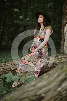 Beautiful outdoor pregnant woman portrait in autumn nature in forest