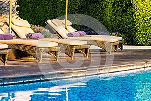 Beautiful outdoor swimming pool with bed deck chair and umbrella in resort for travel and vacation